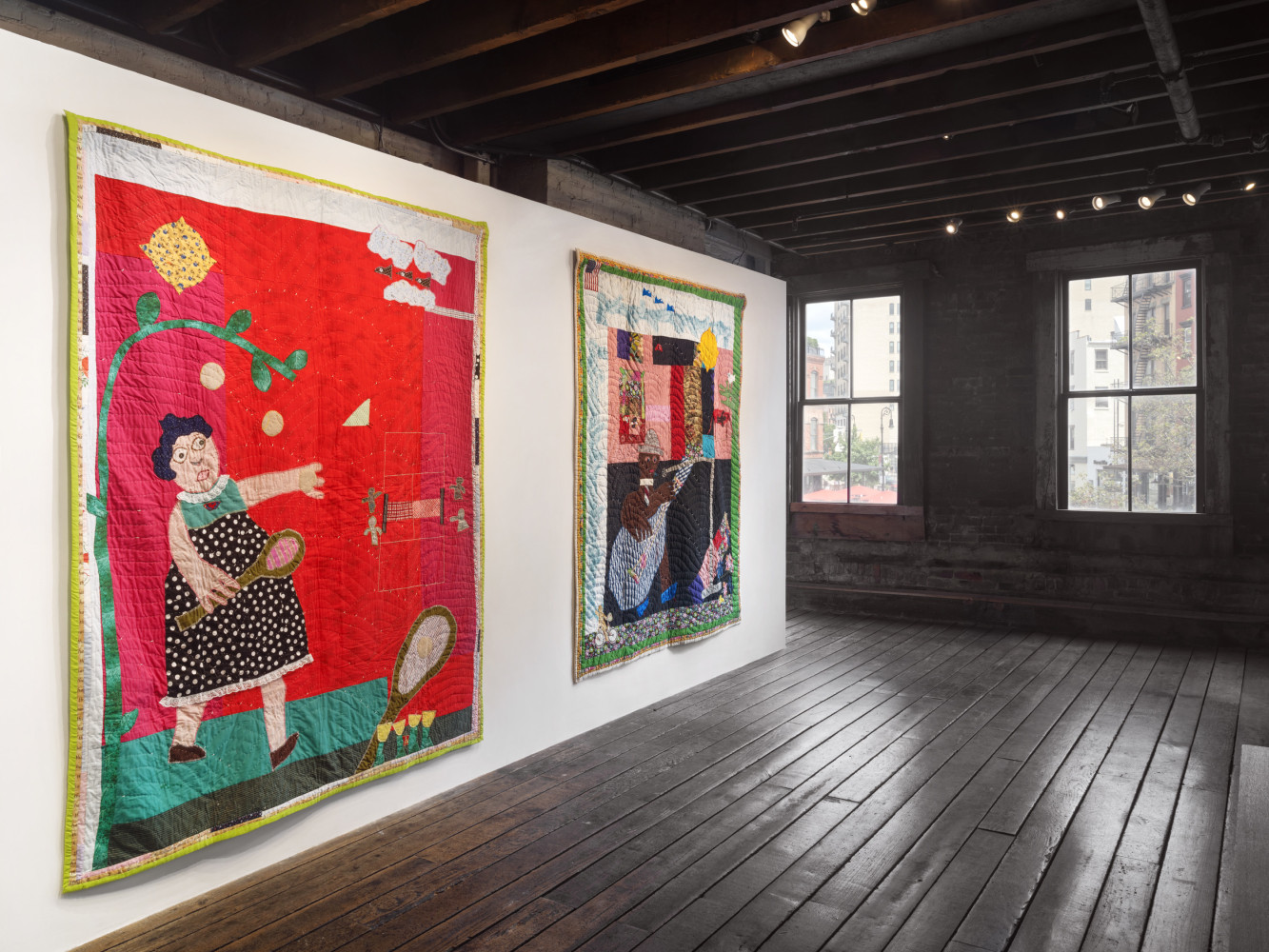 An image on the second floor of two quilts with a window in the background