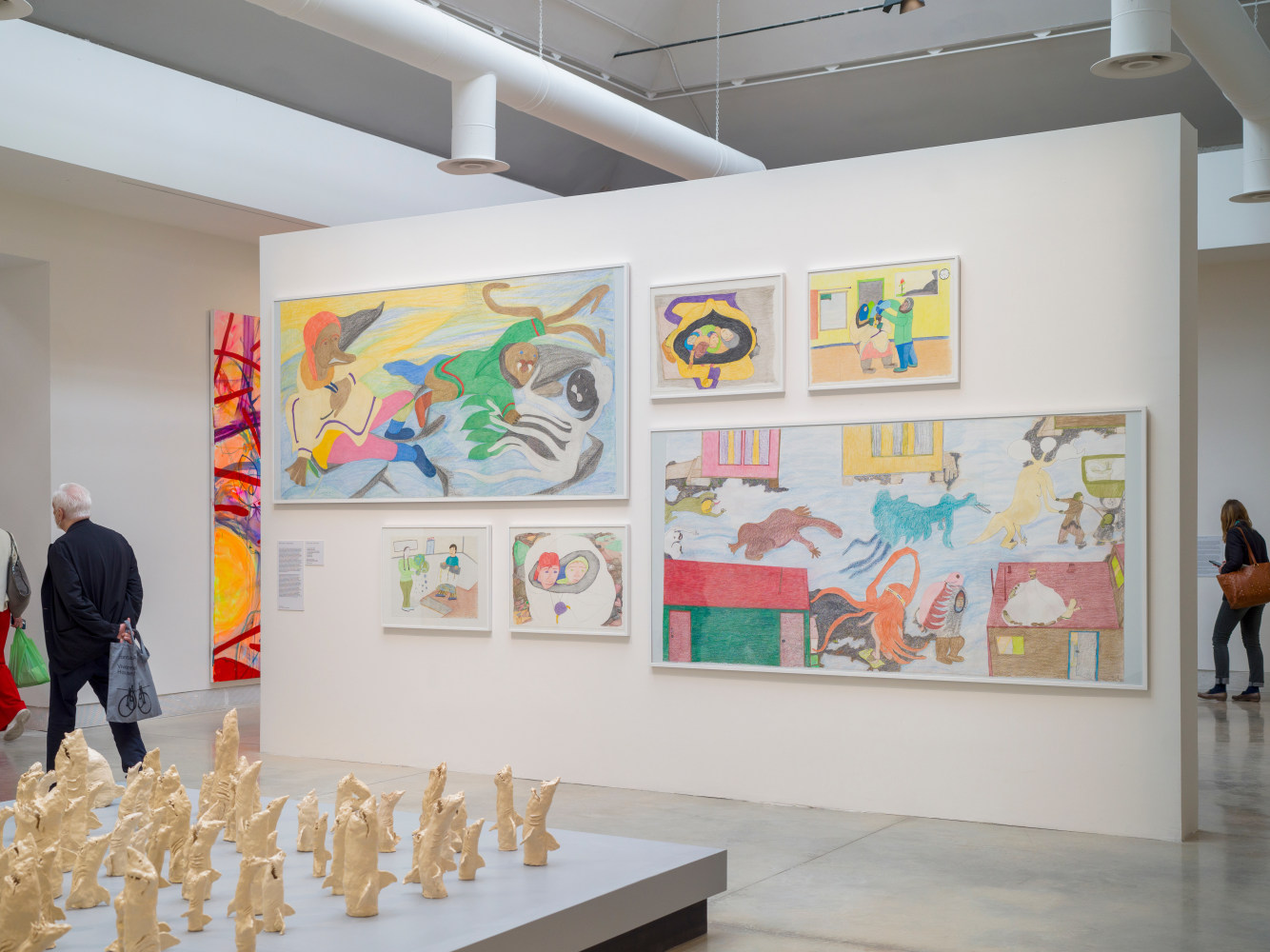 Installation view of artist Shuvinai Ashoona's drawings hung up on a white wall.