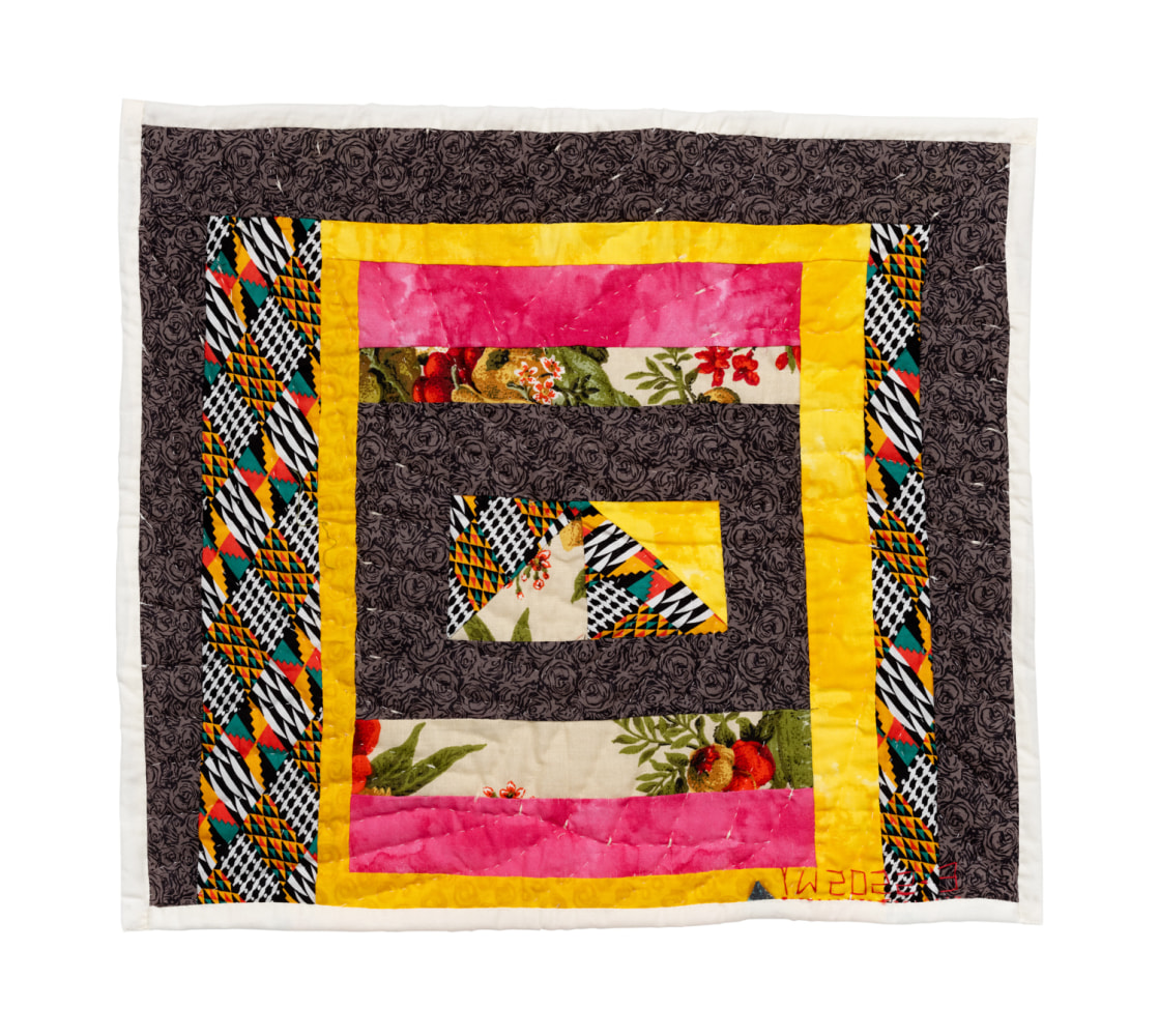 An assorted fabric quilt with colorful squares against a dark brown background