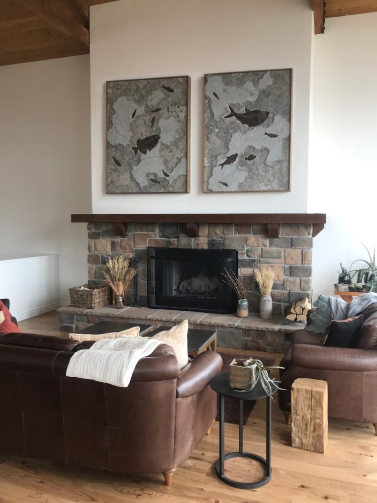 A fossil fish duptich that was quarried from a dark limestone layer hangs above a stone fireplace