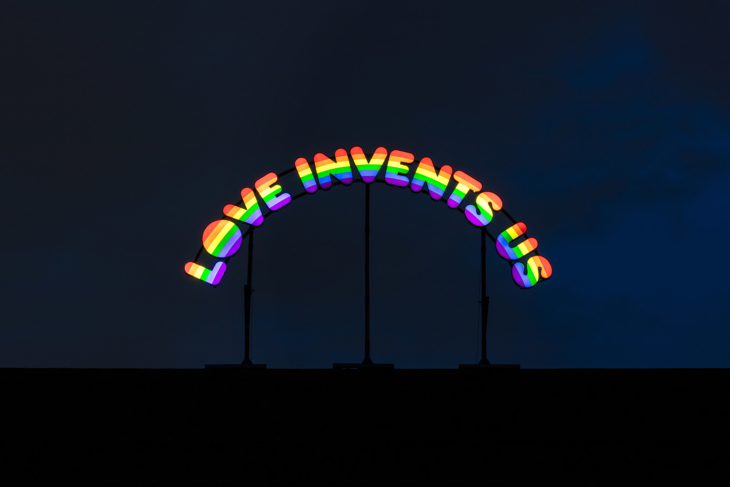 Installation view of colorful clown sculptures and rainbow colored windows by Ugo Rondinone