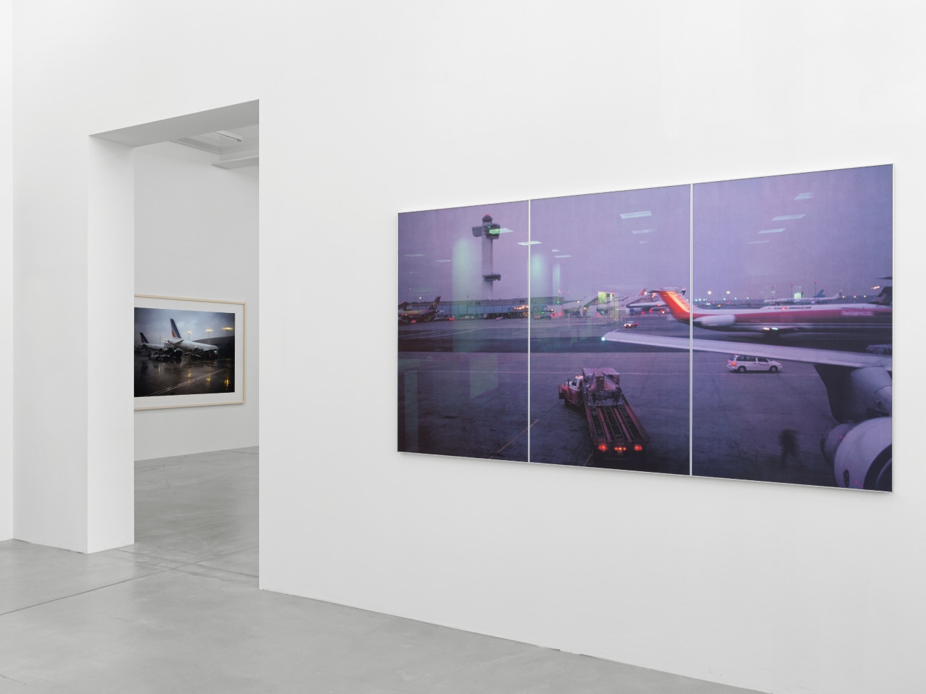 installation view of photographs of airports and car sculptures by Peter Fischli and David Weiss