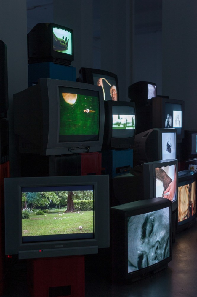 Douglas Gordon Pretty much every film and video work from about 1992 until now. 1999 82 video works on 101 TV monitors, video players, beer crates Installation 200 x 1530 x 620 cm / 78 3/4 x 602 3/8 x 244 1/8 in