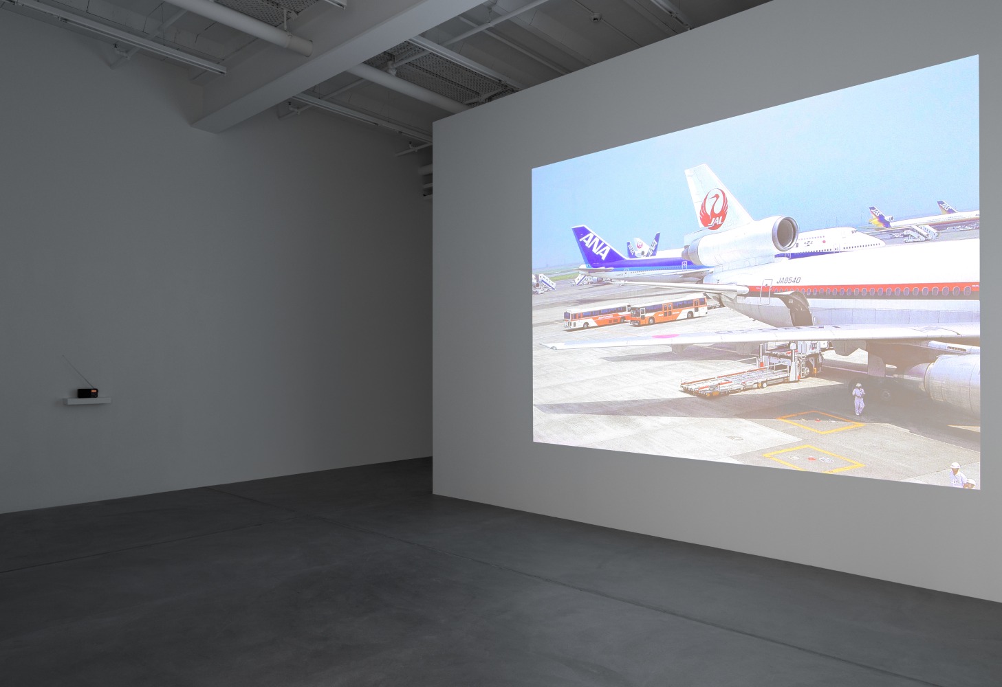 installation view of photographs of airports and car sculptures by Peter Fischli and David Weiss