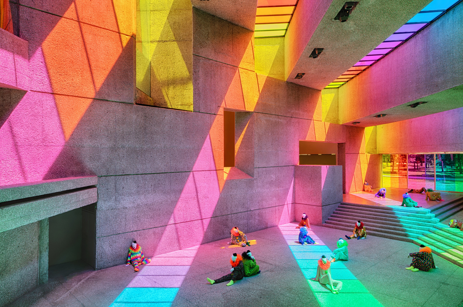 Installation view of colorful clown sculptures and rainbow colored windows by Ugo Rondinone