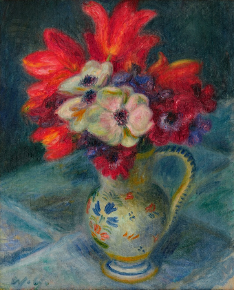bouquet of red anemones and tulips in a french pottery pitcher on a table