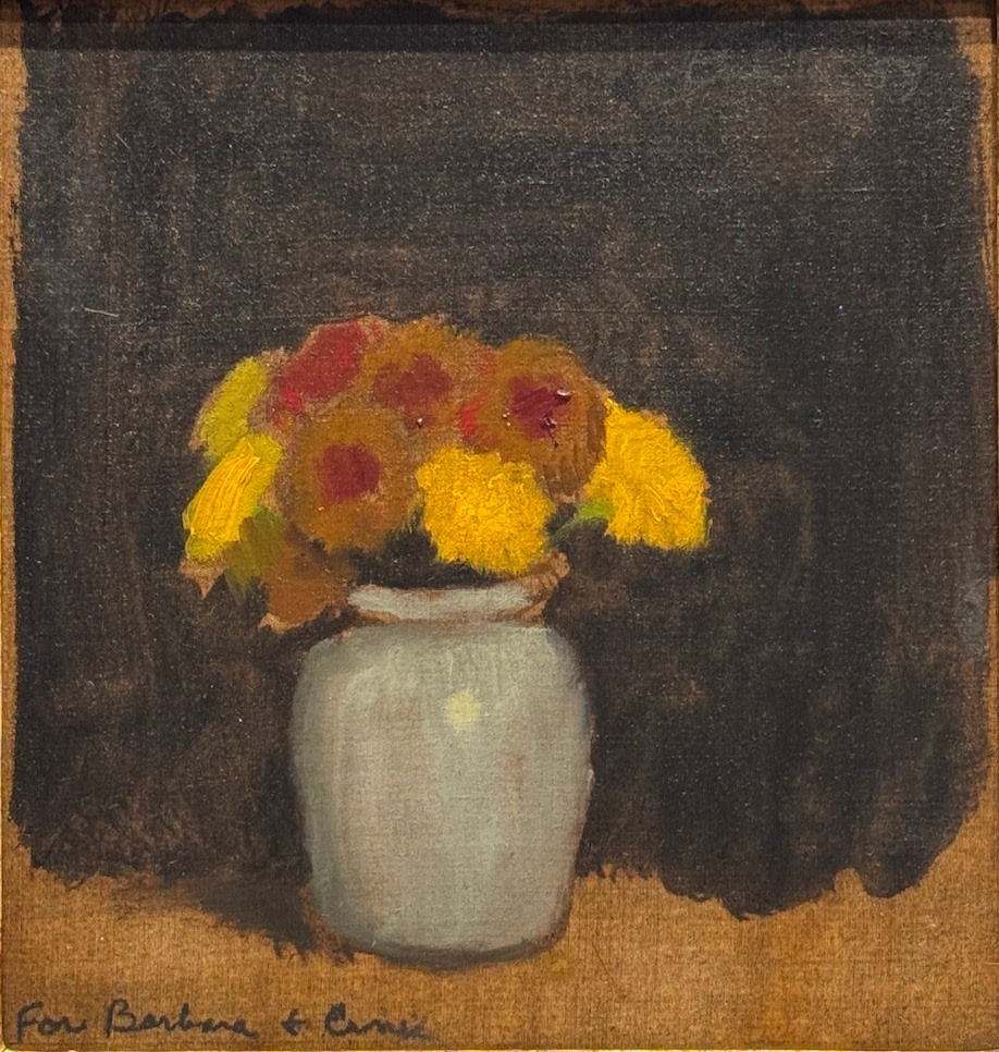 vase of yellow and red flowers on a table against a black background, vase is a pale blue