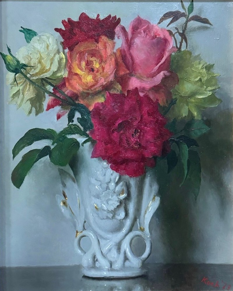 small bouquet of multi colored roses in an ornate milk glass vase
