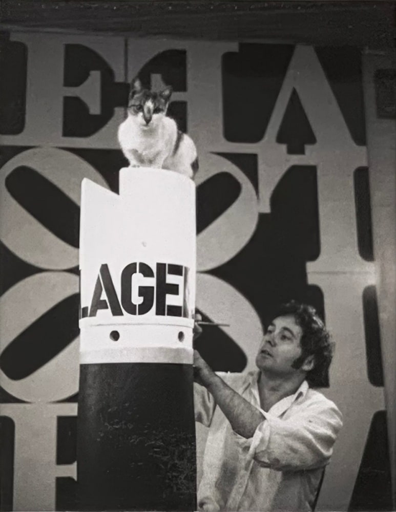 Polaroid of the artist in his studio at 25 Coenties Slip in New York making Flagellant (1963/1969) with Love Rising (The Black and White Love) (1968) in the background. Image courtesy of The Robert Indiana Legacy Initiative and Star of Hope Foundation, Vinalhaven, Maine
