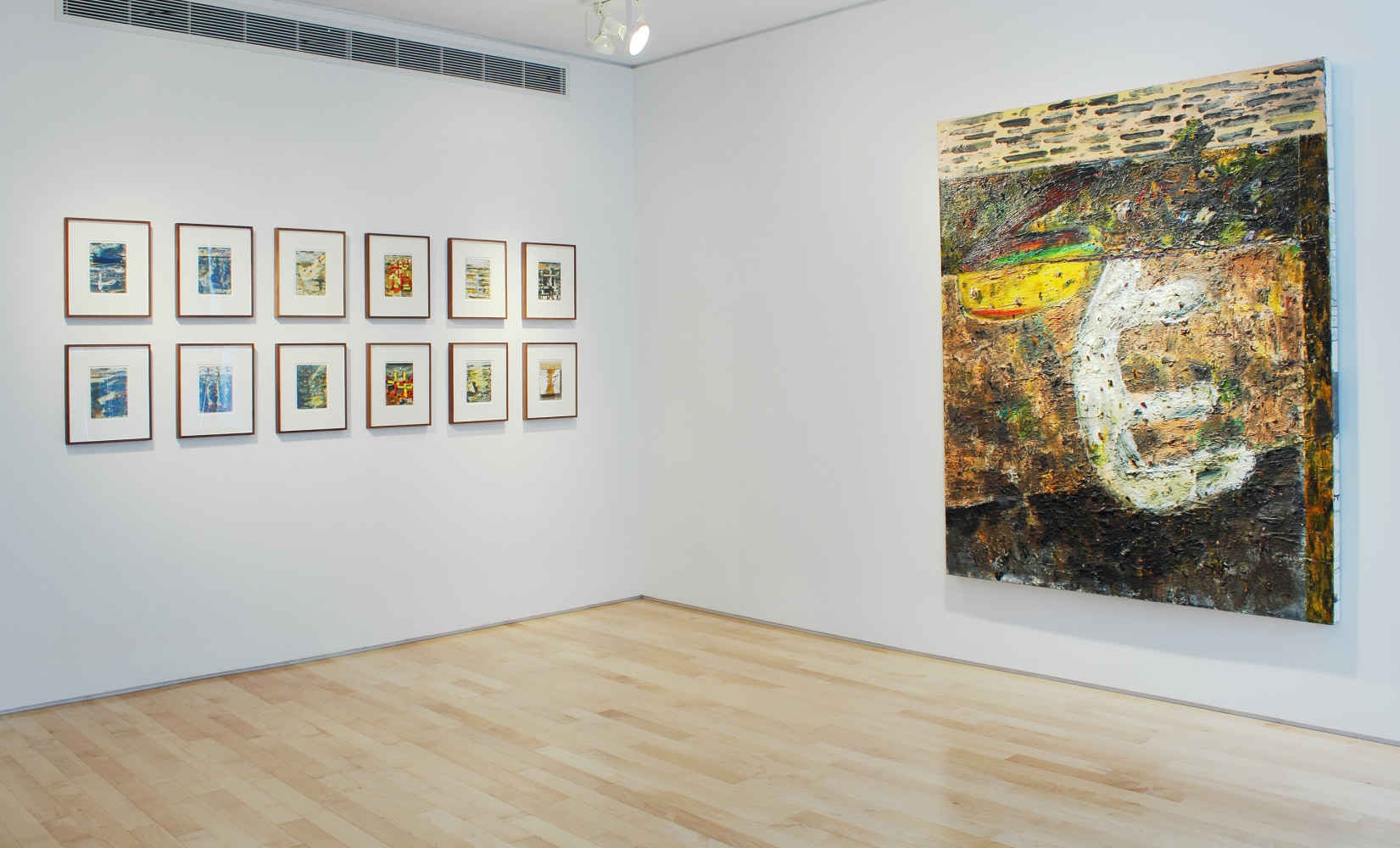 Photograph showing a corner view of an exhibition space, with one large painting and twelve small framed drawings hanging on white walls