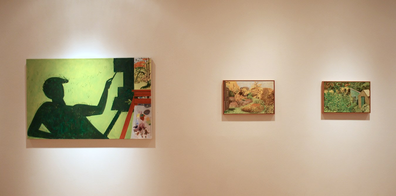 Photograph showing a view of an exhibition, with three paintings hanging on a white wall