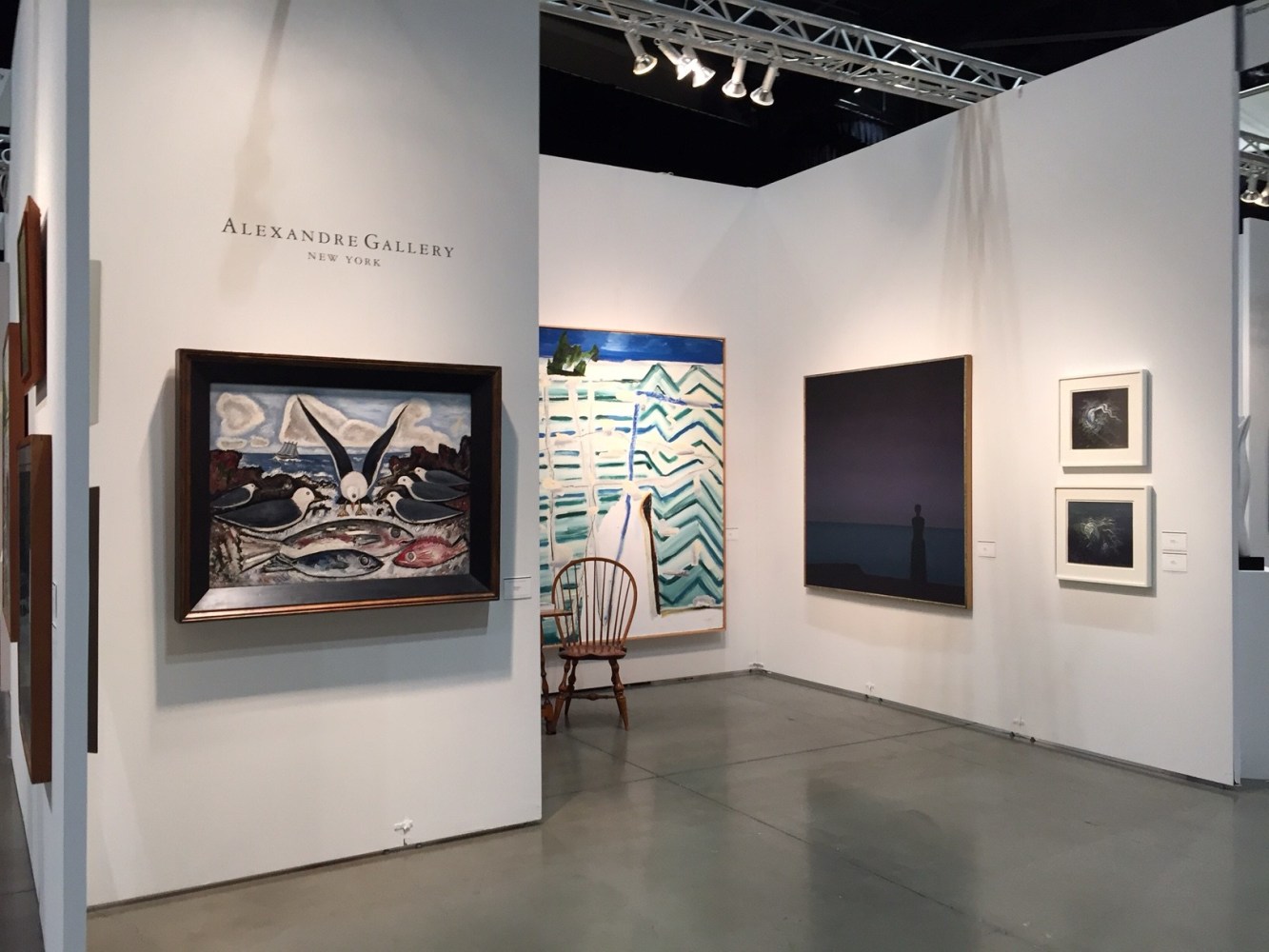 Photograph showing a view of an exhibition space, with five paintings of various sizes hanging on white walls