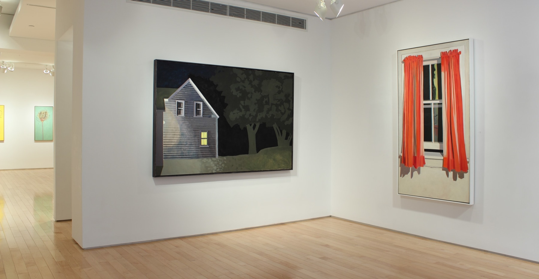 Photograph showing a view of an exhibition space, with two paintings hanging on white walls