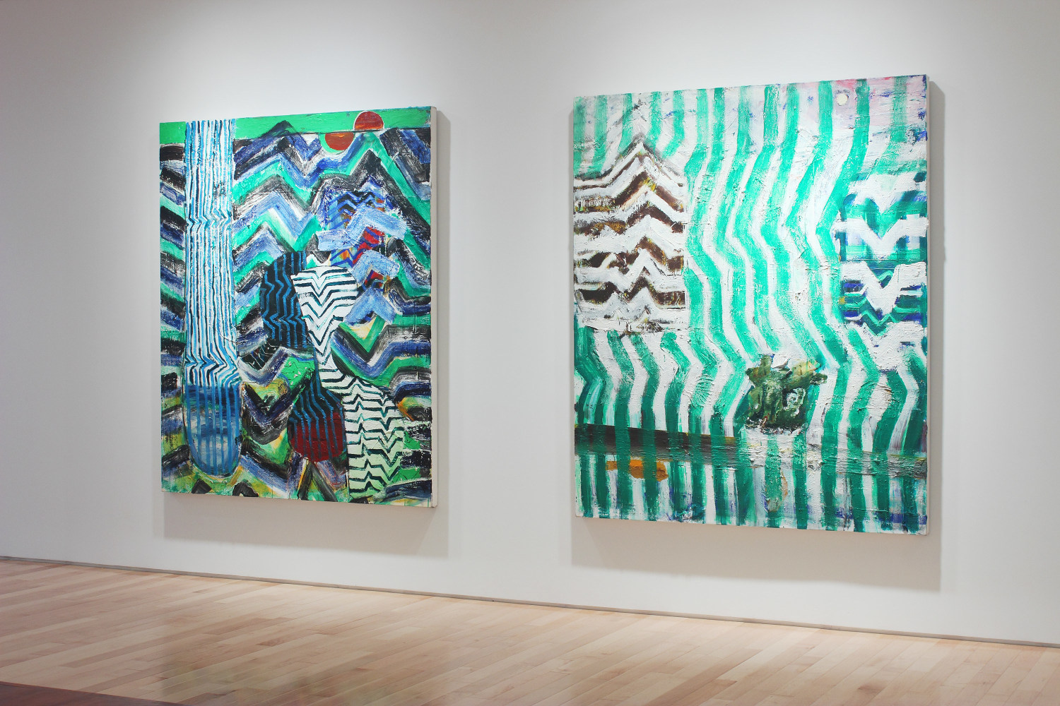 Photograph showing a view of an exhibition space, with two large paintings hanging on a white wall