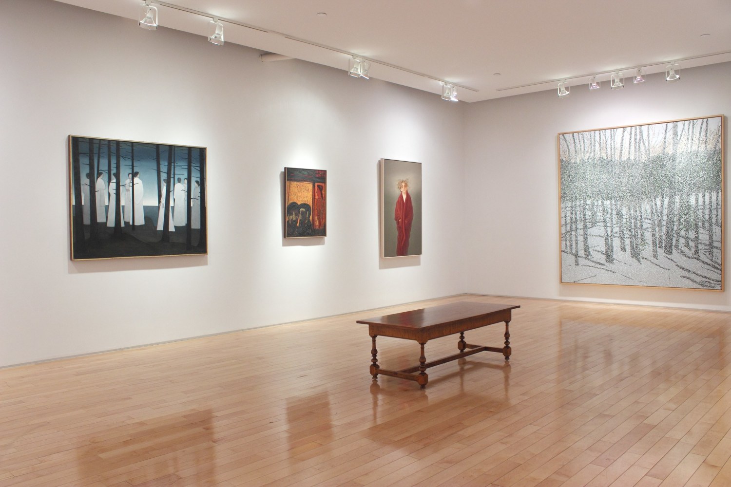 Photograph showing a corner view of an exhibition space with four paintings hanging on white walls