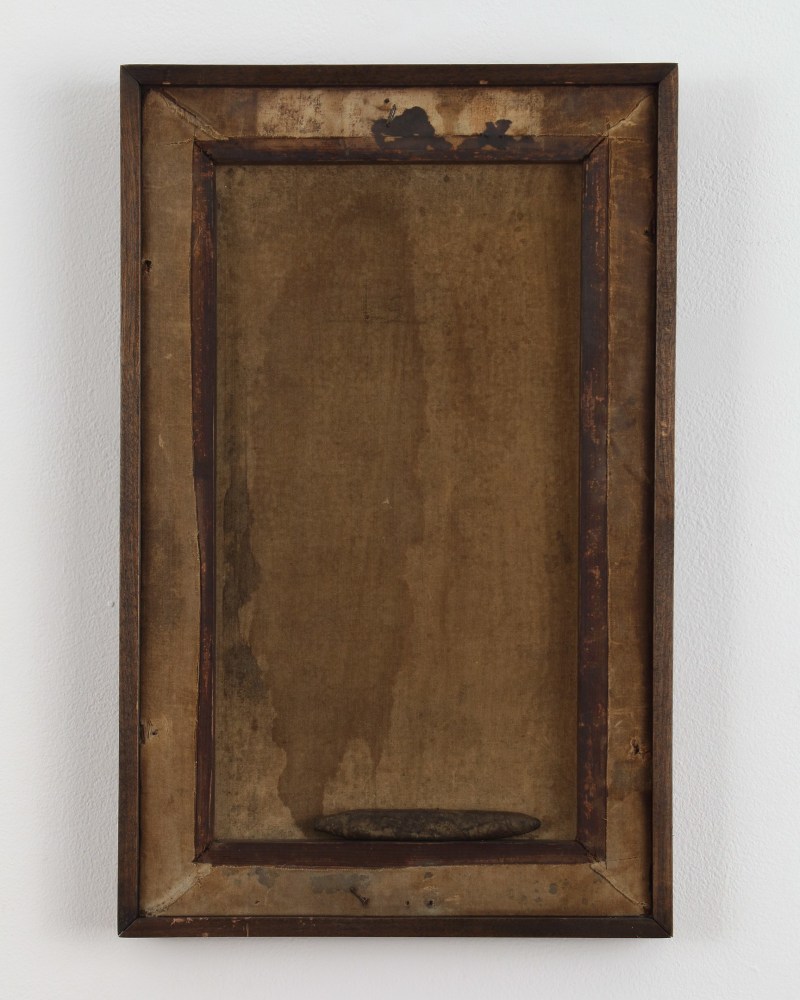 Collage with the image of a hole and faint image of smoke juxtaposed onto a piece of wood, in a frame