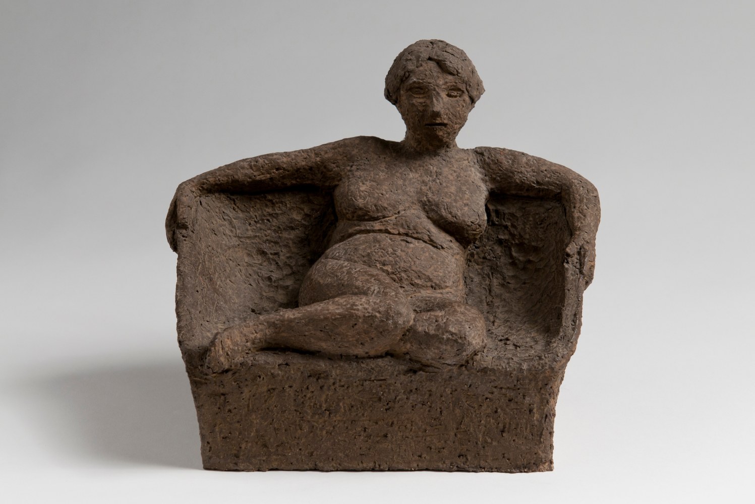 Terra cotta sculpture of a nude figure seated in a chair