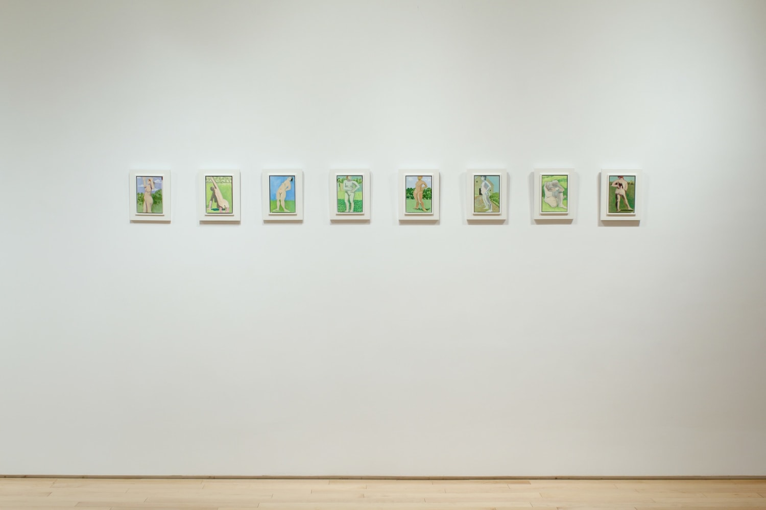 Photograph showing a view of an exhibition space, with a row of eight small paintings hung on a white wall