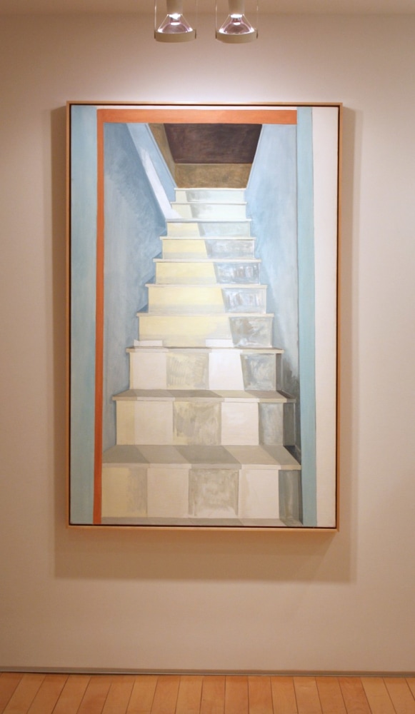 Photograph showing a view of an exhibition, with one large framed painting hanging on a white wall