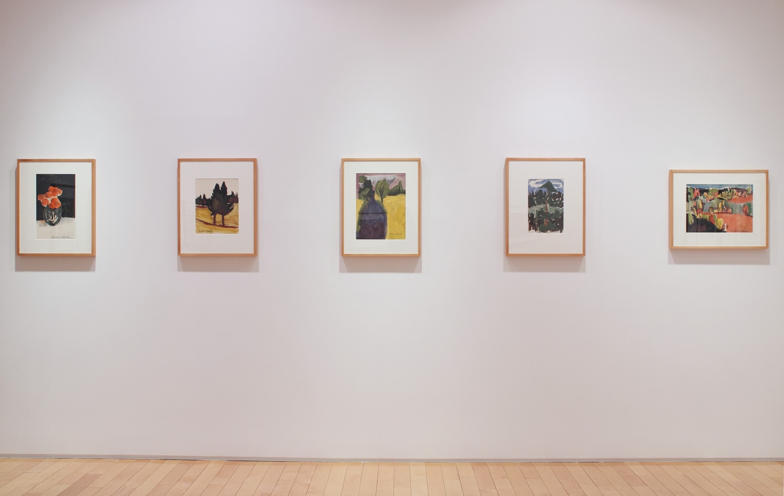 Photograph showing a view of an exhibition space with five framed paintings hanging on a white wall