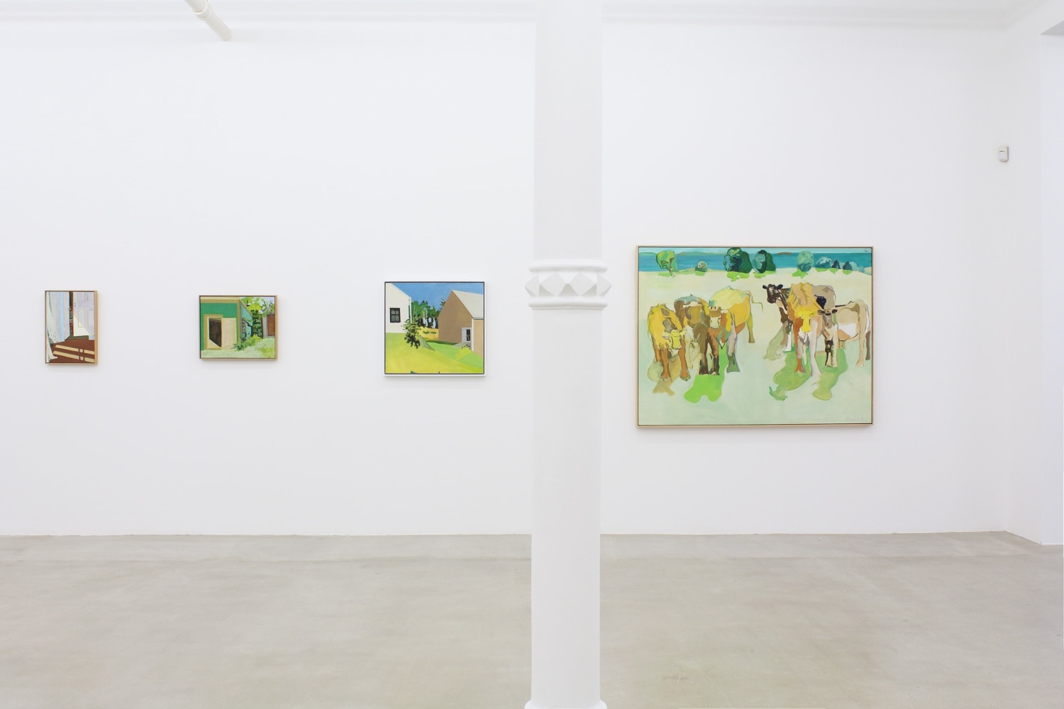 Photograph showing a view of an exhibition space, with four paintings hanging on a white wall