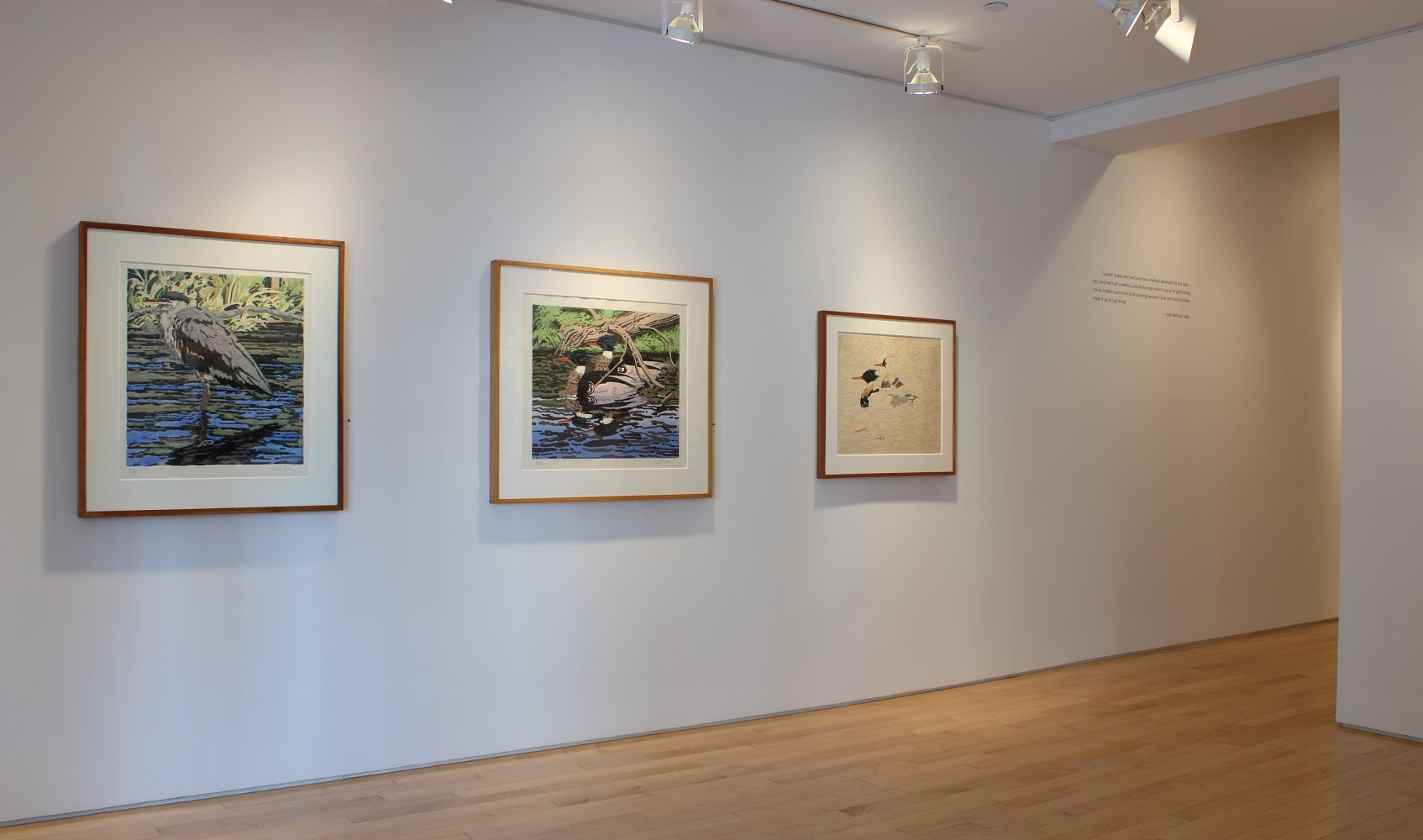 Photograph showing an view of an exhibition with three paintings hanging on white walls