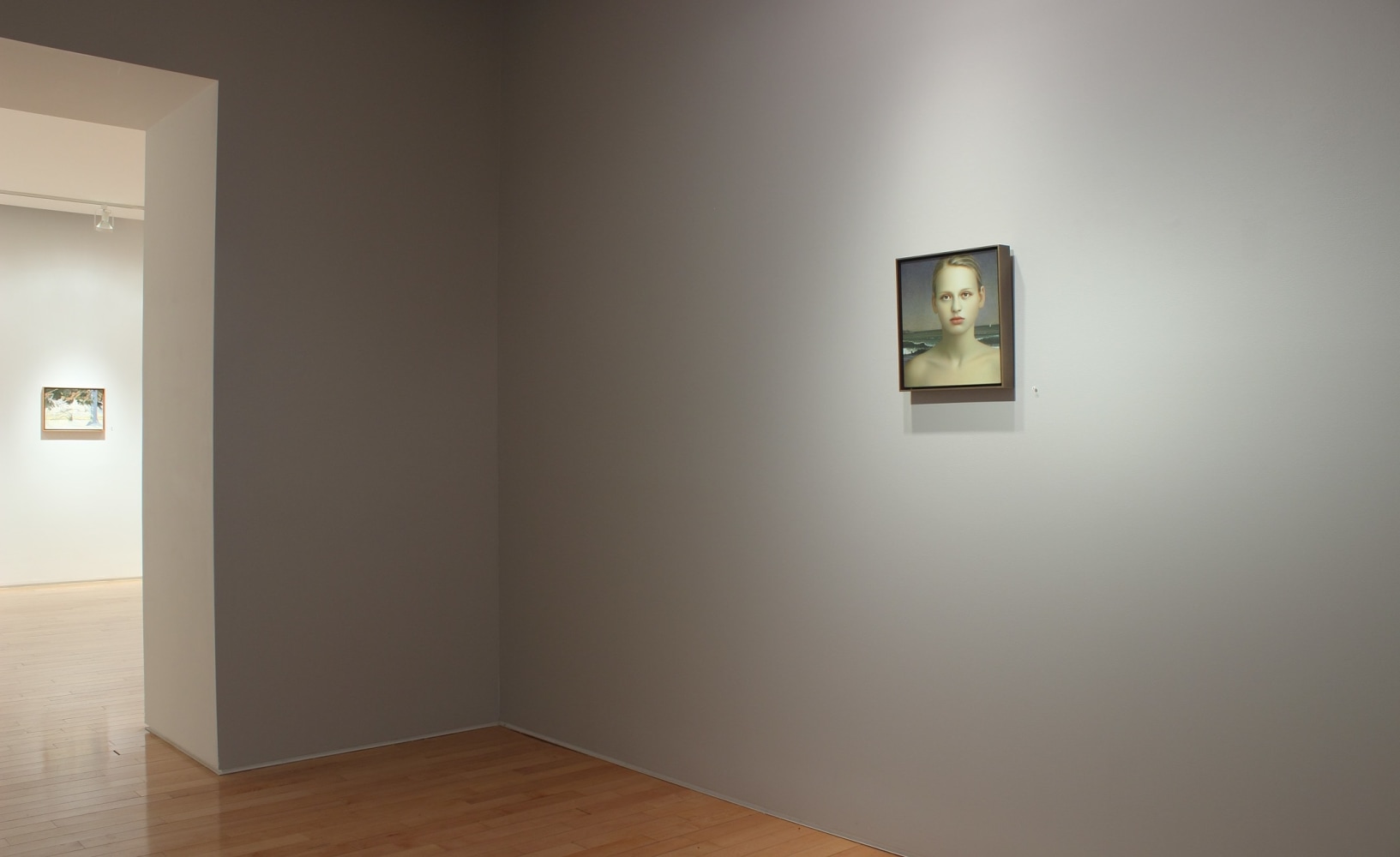 Photograph showing a view of an exhibition space with one small painting hanging on a wall