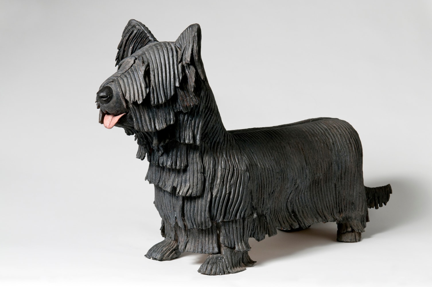 Three-quarter view of a sculpture of a small, shaggy dog