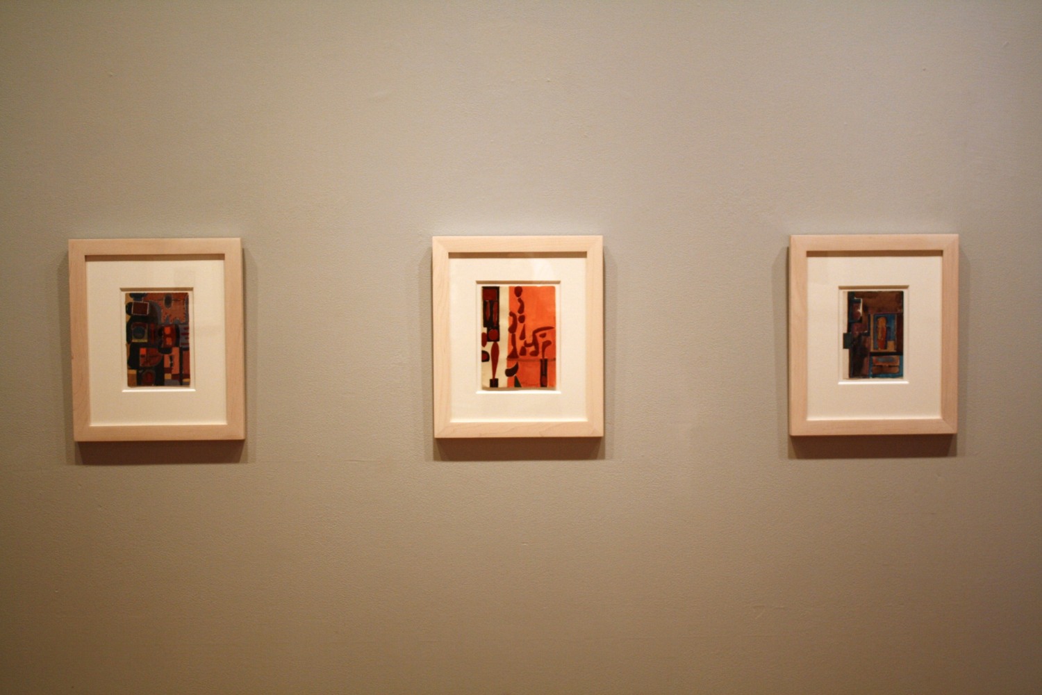Photograph showing a view of an exhibition, with two small framed drawings hanging on a grey wall