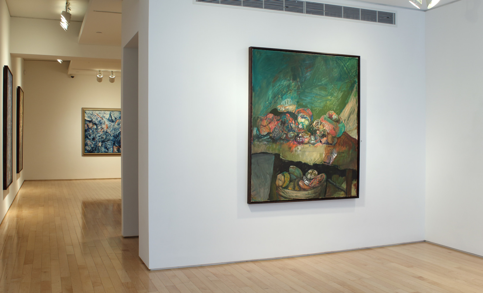 Photograph showing a front view of an exhibition space with two paintings hanging on white walls