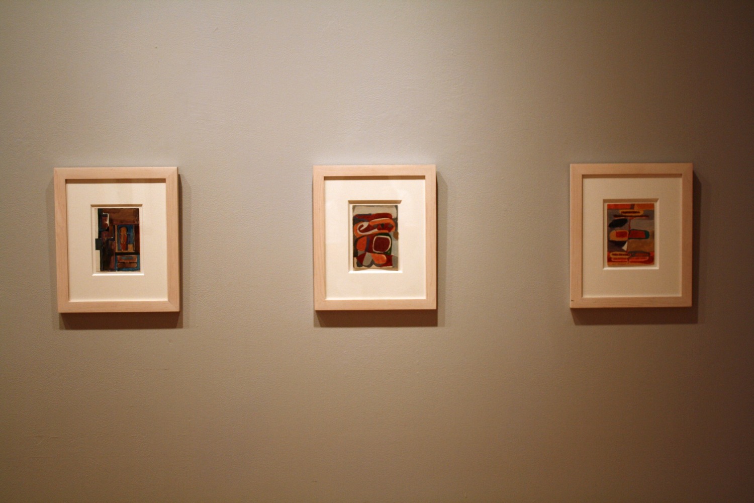 Photograph showing a view of an exhibition, with two small framed drawings hanging on a grey wall
