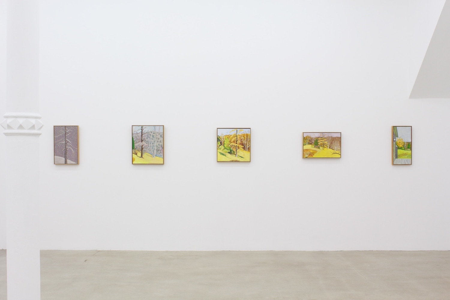 Photograph showing a view of an exhibition space with five paintings hung on a white wall