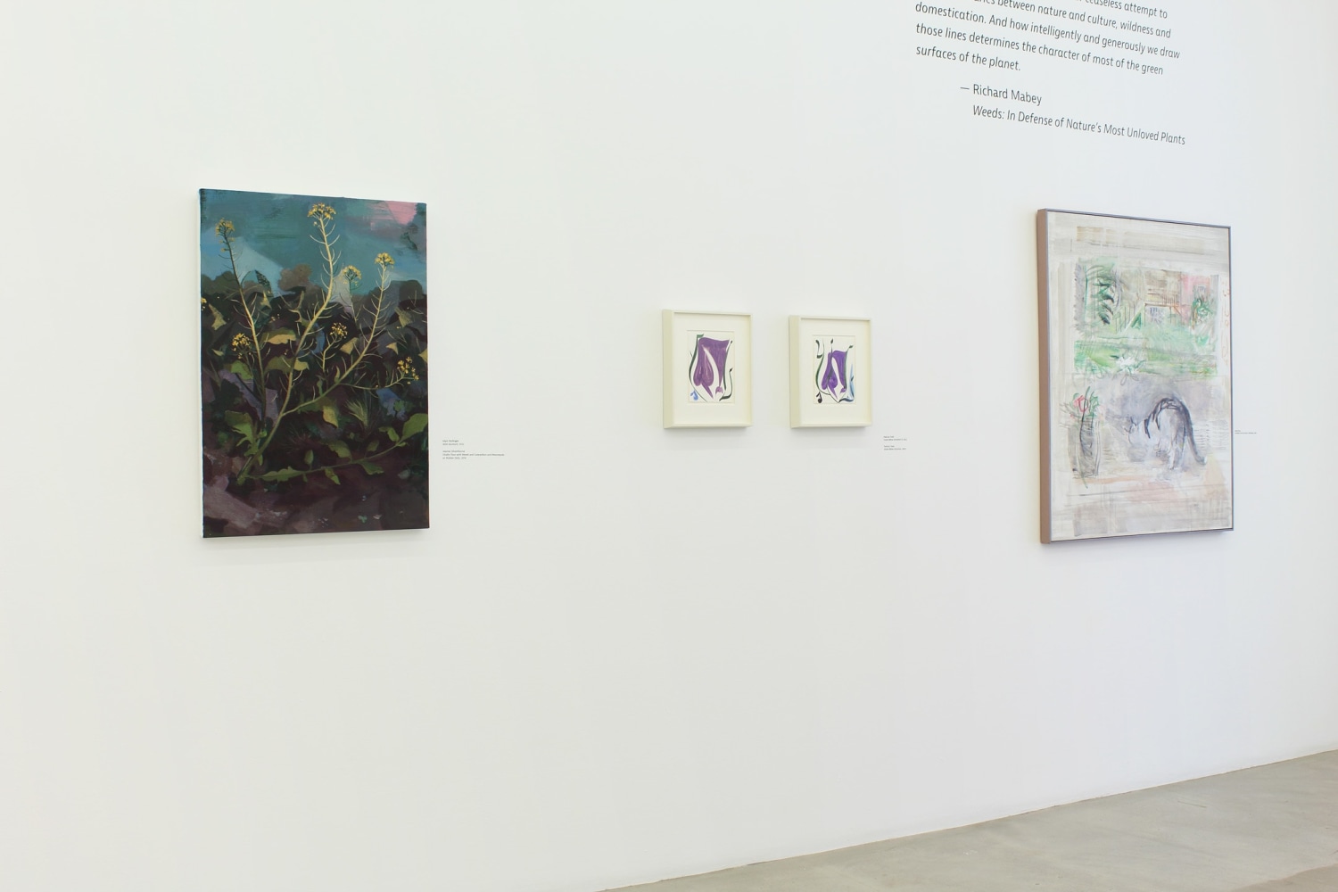 Photograph of a detail view of an exhibition with four paintings hung on a white wall