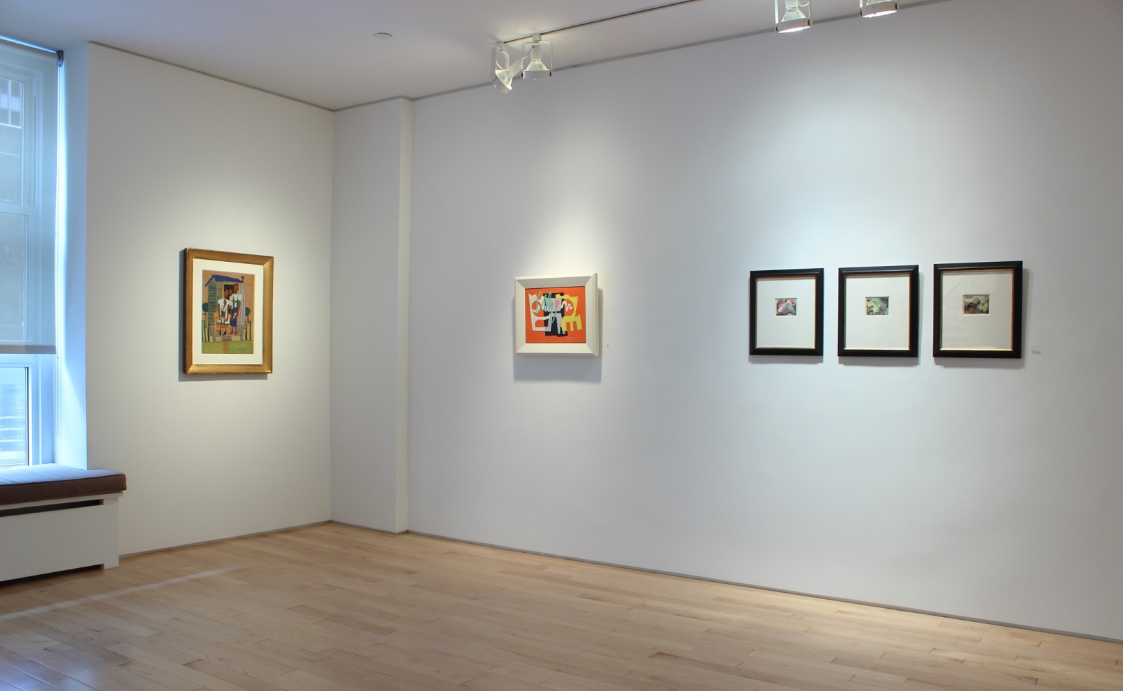 Photograph showing a corner view of an exhibition space, with two paintings and three framed watercolors hanging on white walls