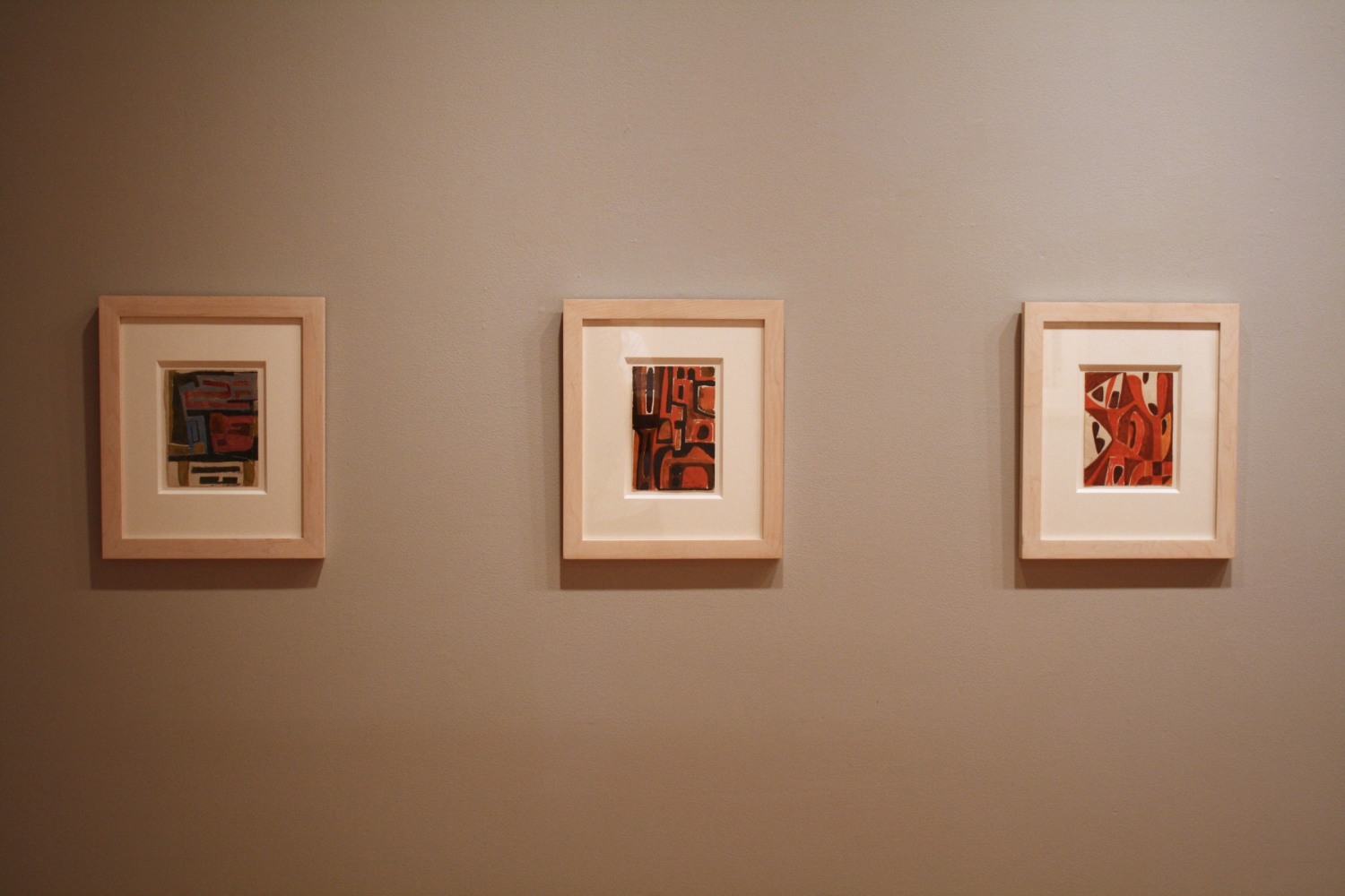 Photograph showing a view of an exhibition, with two small framed drawings hanging on a grey wall