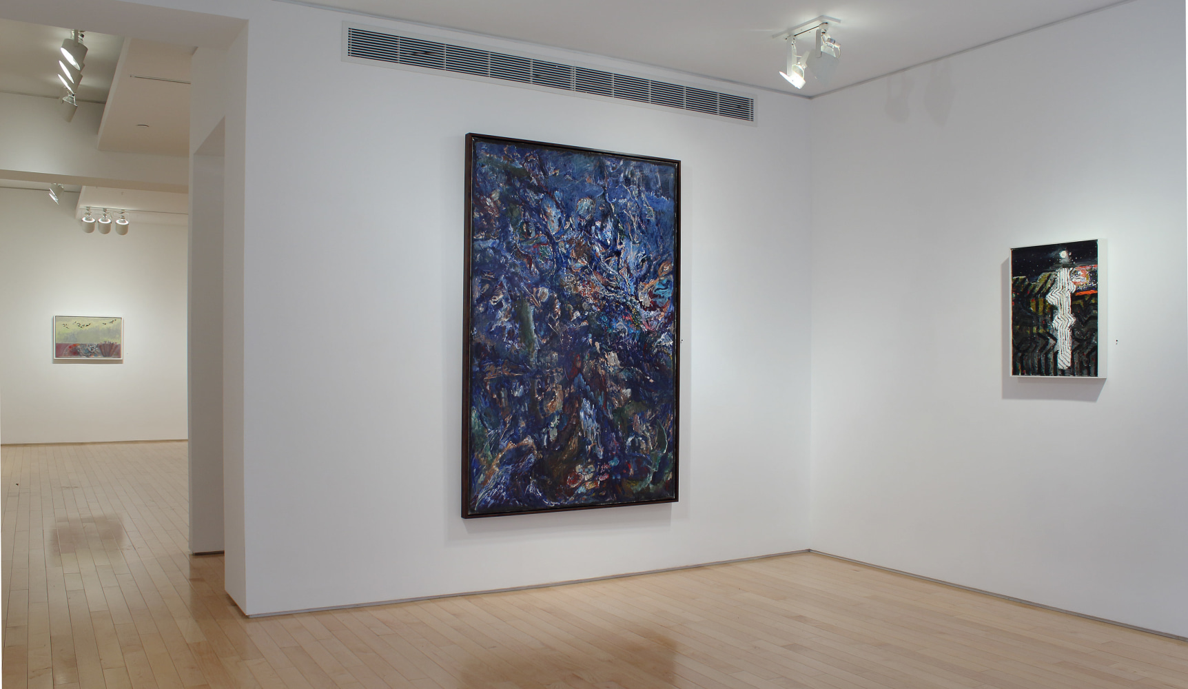 Photograph showing a corner view of an exhibition space, with two paintings hanging on white walls