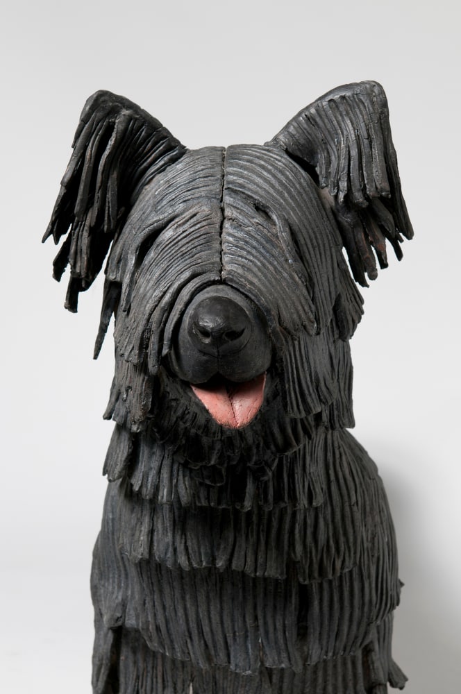 Detail view of a sculpture of a small, shaggy dog