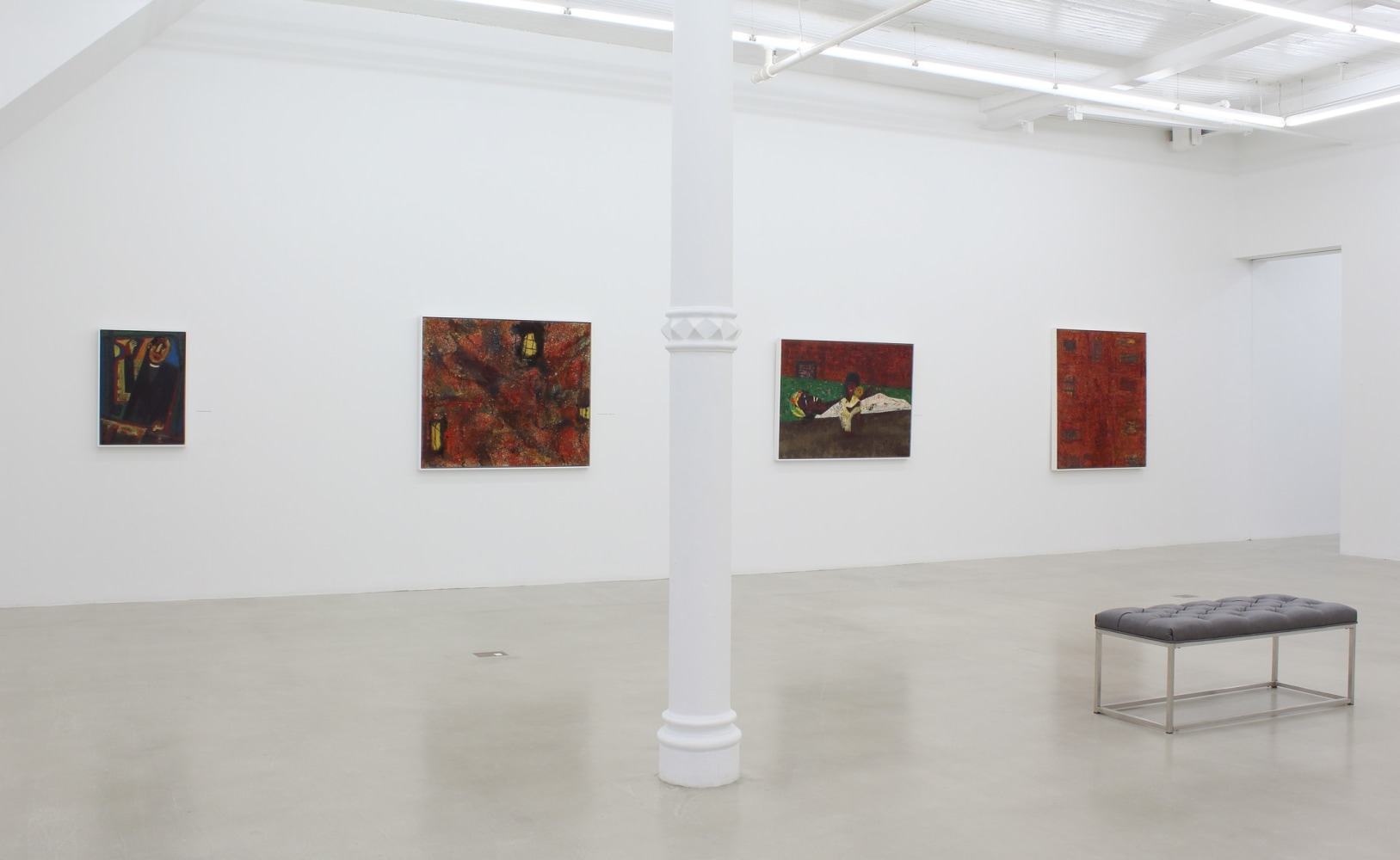 Photograph showing a view of an exhibition space, with four paintings hanging on a white wall