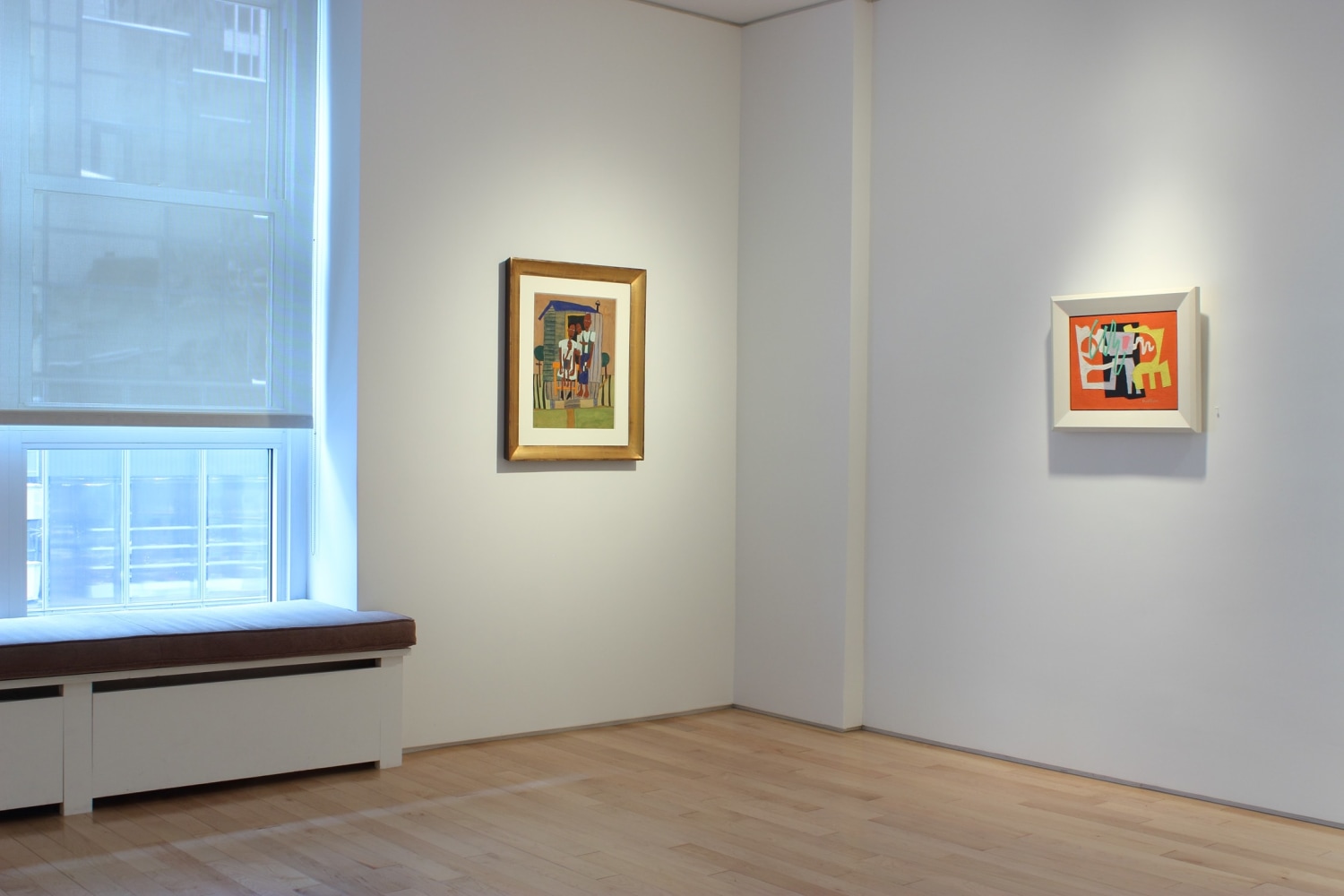 Photograph showing a corner view of an exhibition space, with two paintings hanging on white walls