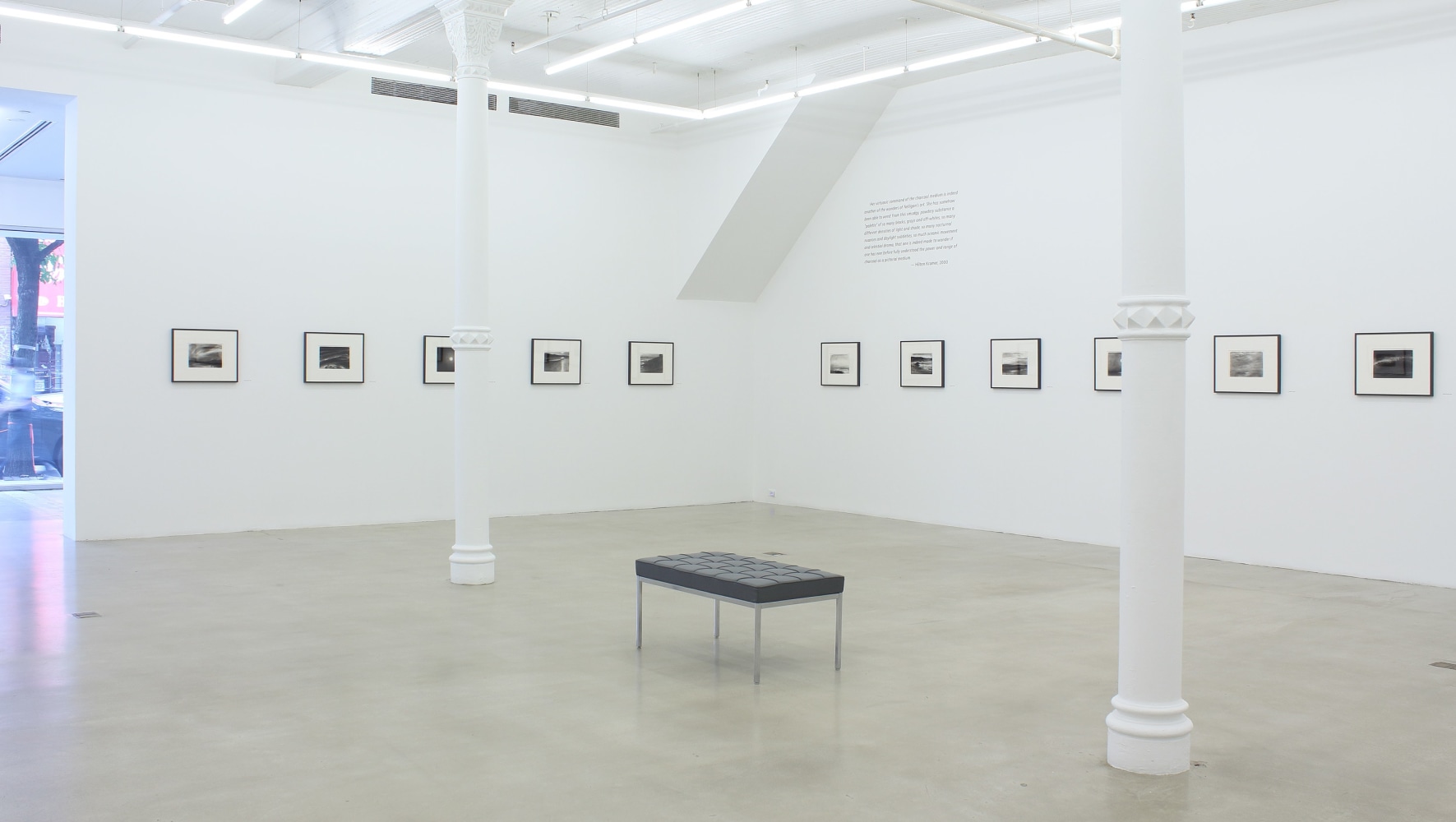 Photograph of eleven framed drawings in a white gallery exhibition space