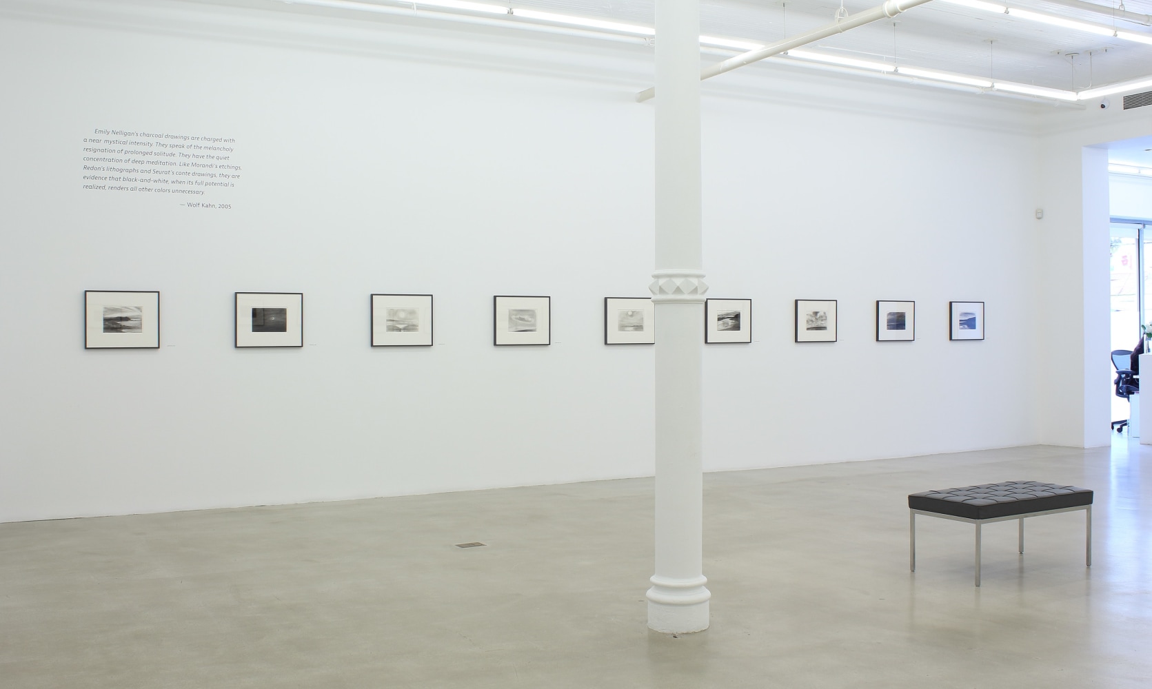 Photograph of nine framed drawings in a white gallery exhibition space