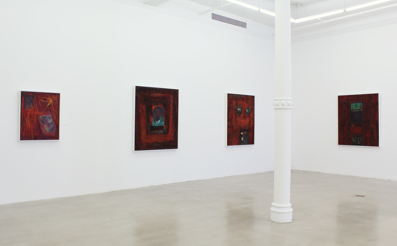 Photograph showing a corner view of an exhibition space, with four paintings hanging on white walls