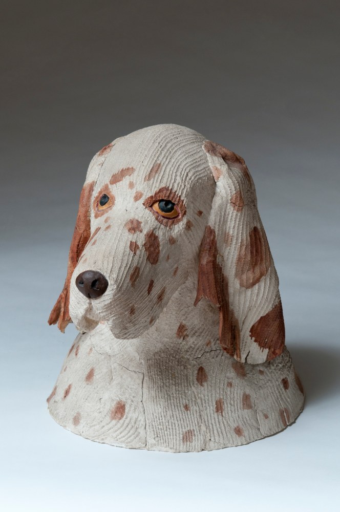 Sculpture of the head of a white dog with brown spots