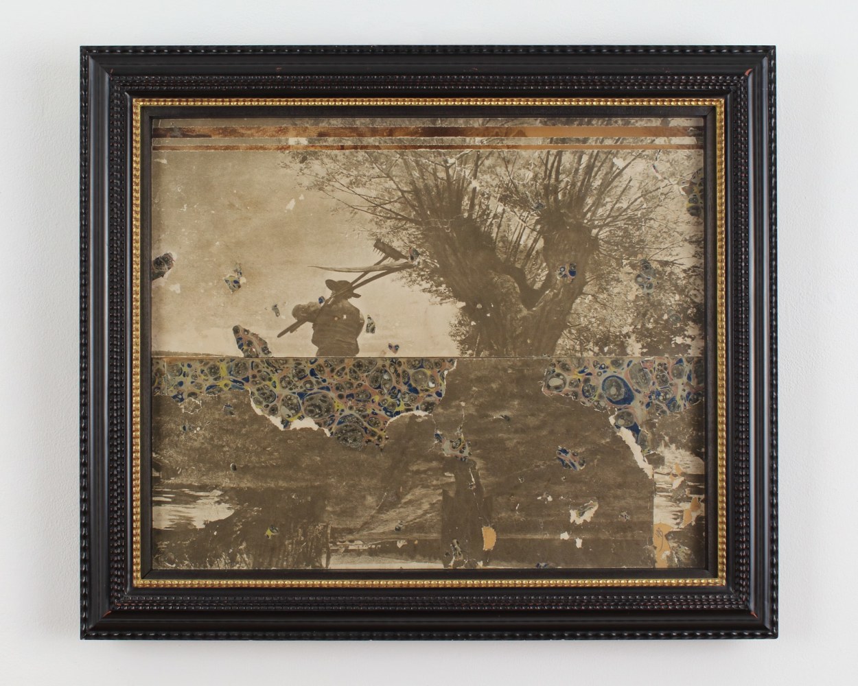 Framed collage made with two black and white photographs showing people working in a field and scraps of patterned paper