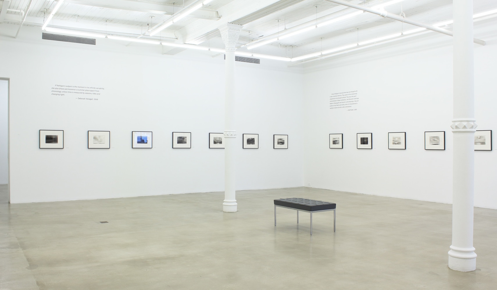 Photograph of twelve framed drawings in a white gallery exhibition space