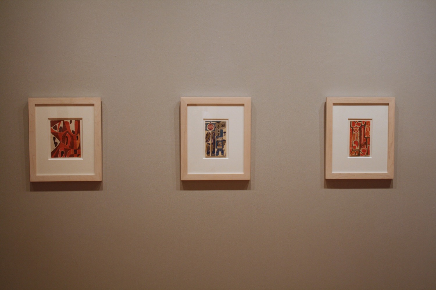 Photograph showing a view of an exhibition, with two small framed drawings hanging on a grey wall