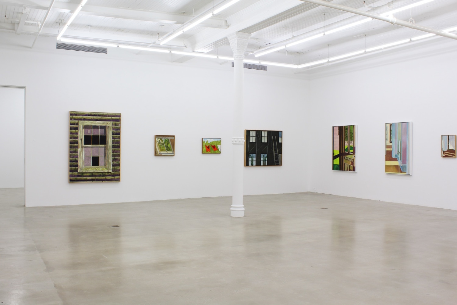 Photograph showing a corner view of an exhibition space, with seven paintings hanging on white walls