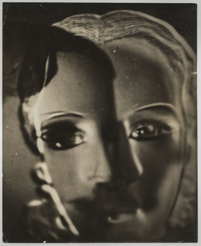 Two masks are superimposed in this Surrealist black and white photograph.