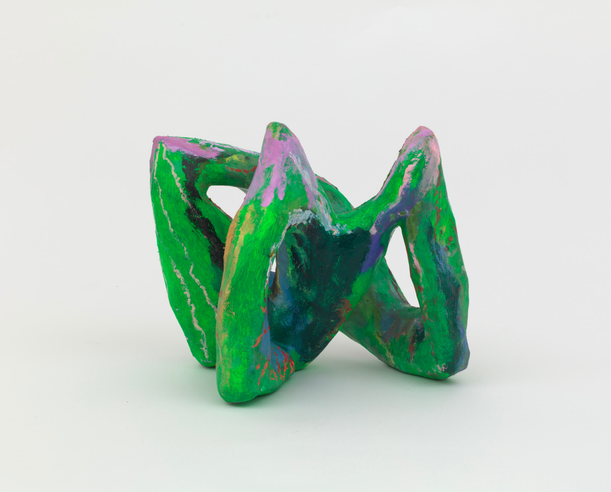 A small green abstract sculpture made from wood and papier maché of three connected pointed forms.