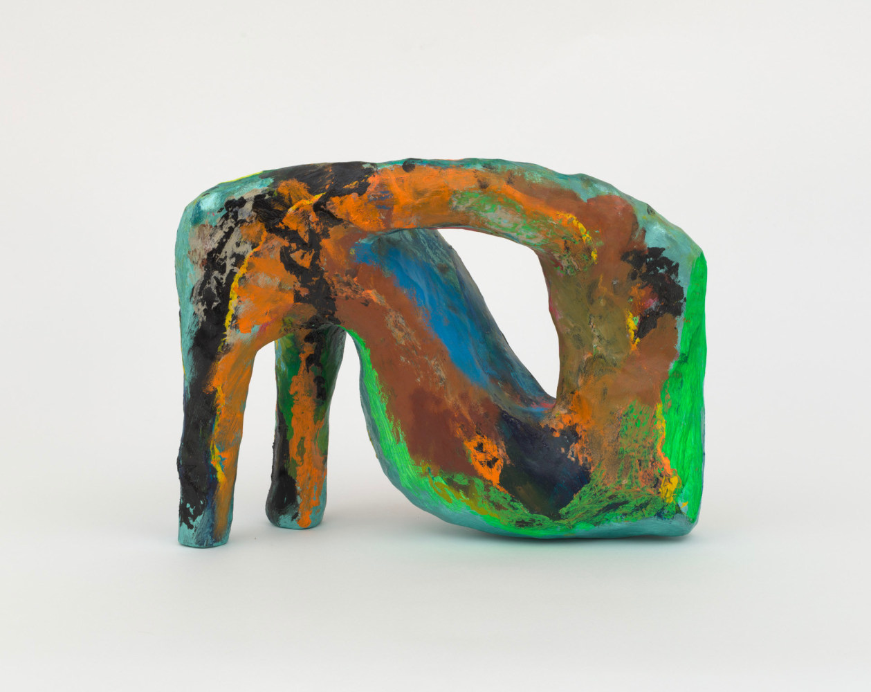 An abstract wood and papier maché sculpture with two bent leg like forms and an open cavity.